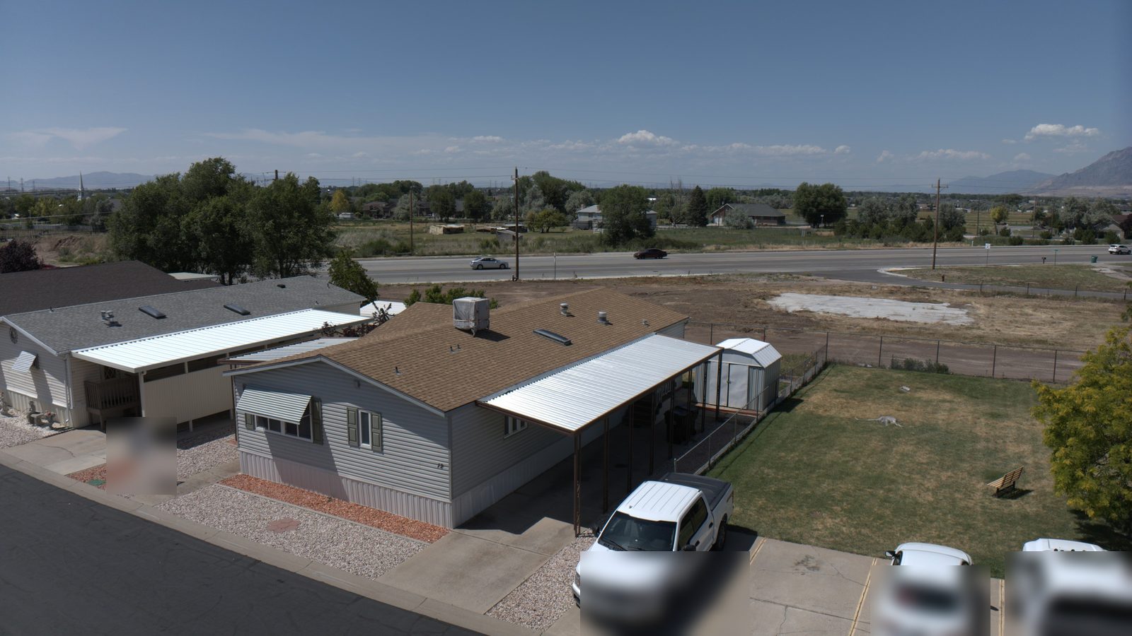 Brown asphalt shingle roof with vents on a Utah home under a clear sky