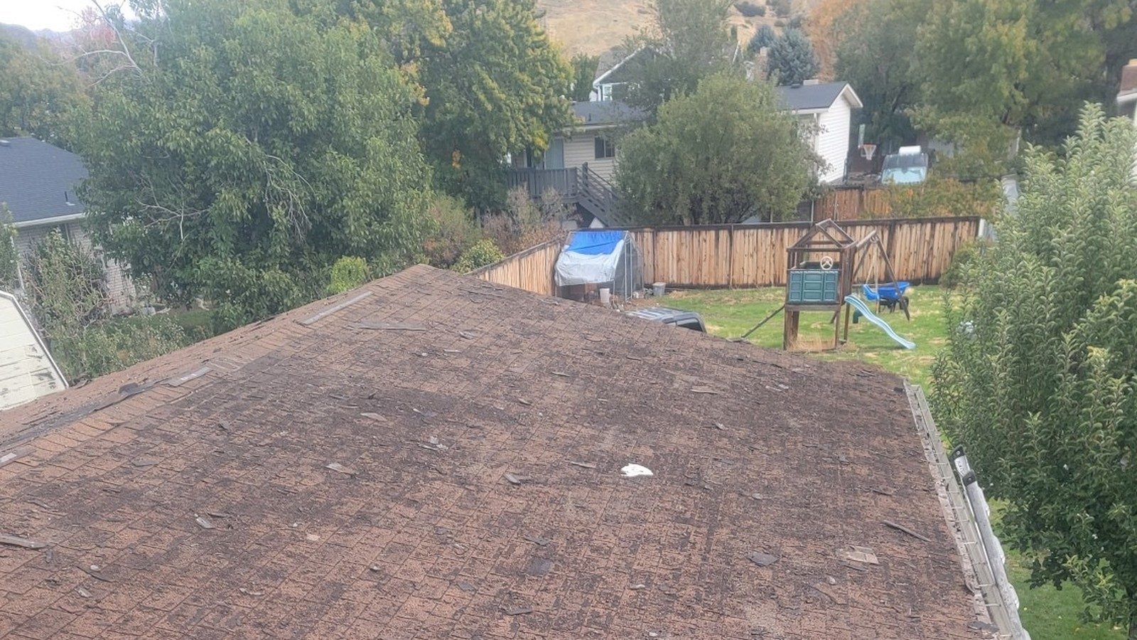 Weathered brown asphalt shingles with damage before a Utah roof replacement