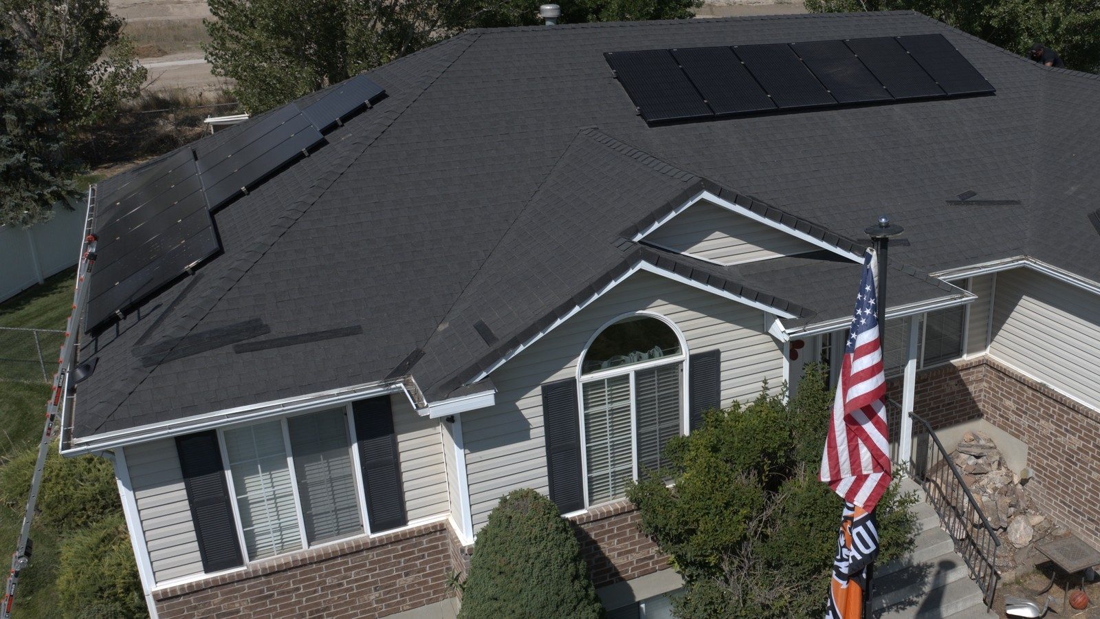Utah home with dark asphalt shingles and solar panels during a roof inspection