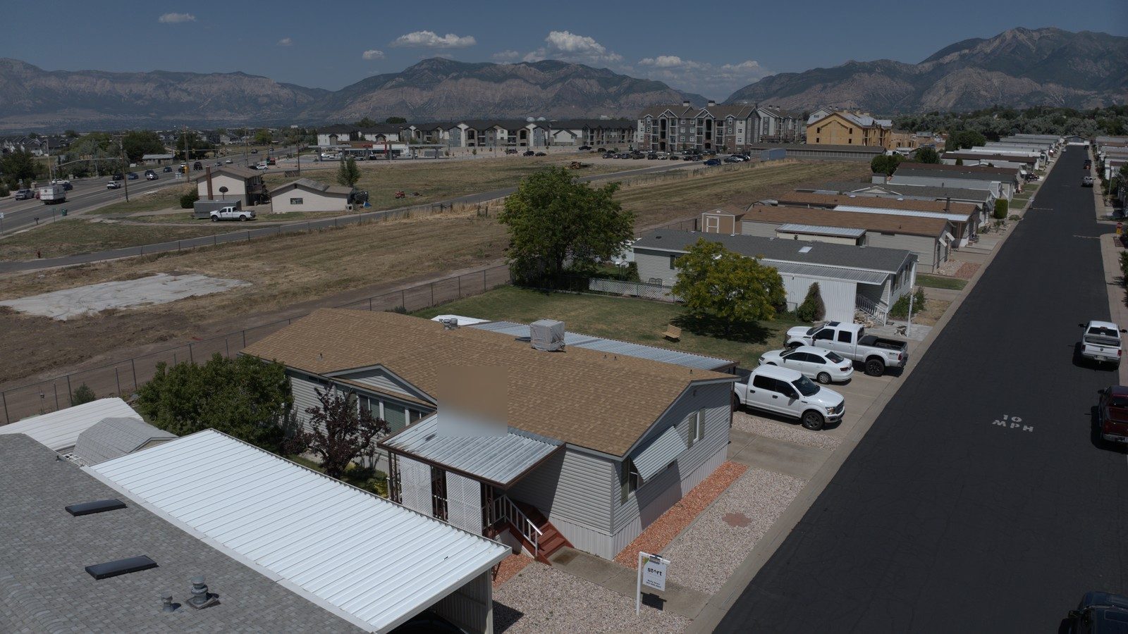 Utah residential street with asphalt shingle roofs and Wasatch mountains in the distance