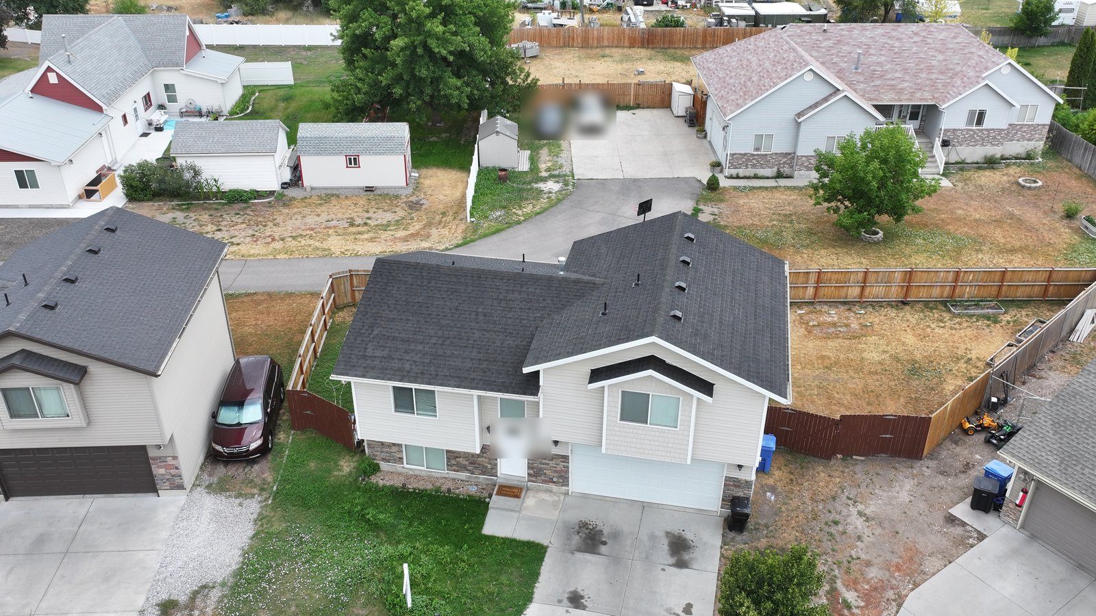 Drone view of a Utah split-level home with a dark gray asphalt shingle roof