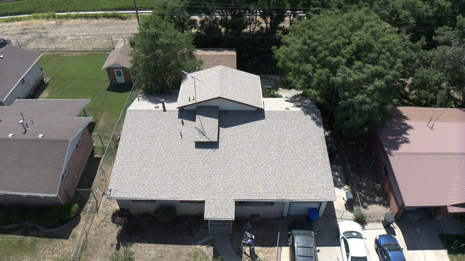 Drone view looking down on a tan asphalt shingle roof on a Utah home