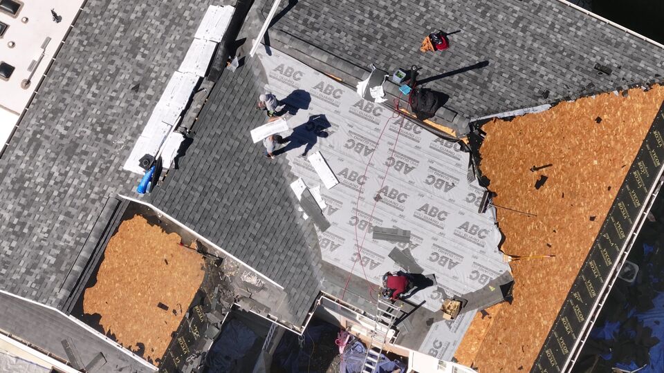 A Utah roof replacement in layers: open deck, underlayment, and new asphalt shingles.